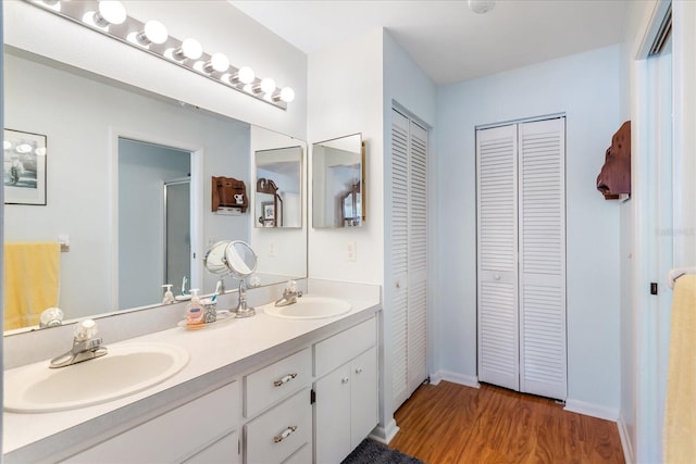 3748 Innisbrook Dr, Lakeland, FL 33810 - bathroom featuring a closet, wood finished floors, a stall shower, double vanity, and baseboards