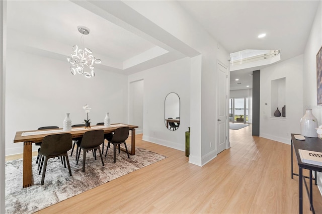 16689 Broadwater Ave, Winter Garden, FL 34787 - dining room with baseboards, an inviting chandelier, a tray ceiling, and light wood-style flooring