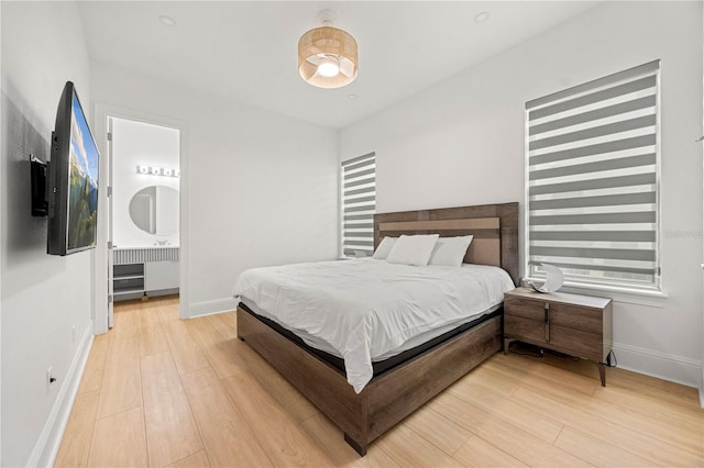 16689 Broadwater Ave, Winter Garden, FL 34787 - bedroom with radiator, ensuite bath, light wood finished floors, and baseboards