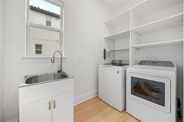 16689 Broadwater Ave, Winter Garden, FL 34787 - laundry room featuring a sink, light wood-type flooring, washer and dryer, cabinet space, and baseboards