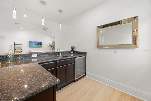 16689 Broadwater Ave, Winter Garden, FL 34787 - kitchen featuring dark stone countertops, a sink, wine cooler, and light wood-type flooring