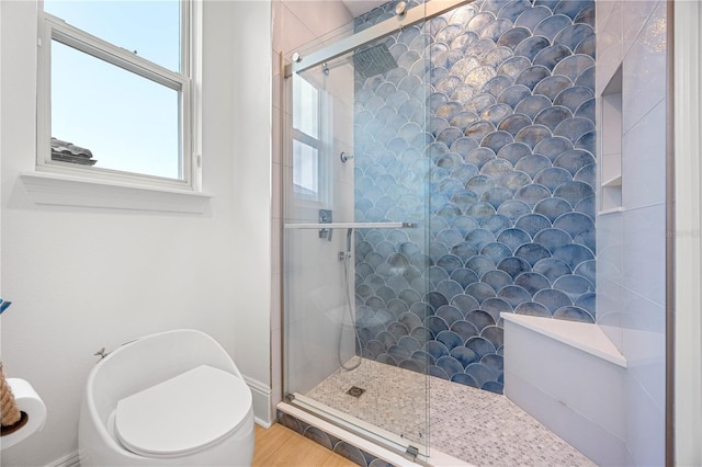 16689 Broadwater Ave, Winter Garden, FL 34787 - bathroom with a tile shower, toilet, wood finished floors, and baseboards