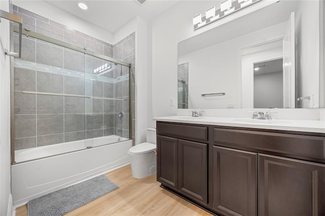 16689 Broadwater Ave, Winter Garden, FL 34787 - full bathroom featuring a sink, double vanity, shower / bath combination with glass door, toilet, and wood finished floors