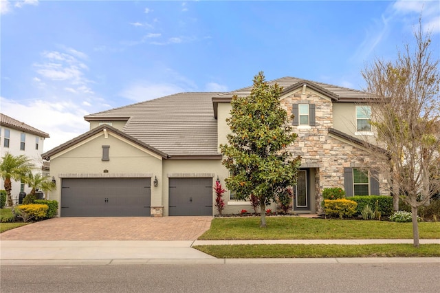 16689 Broadwater Ave, Winter Garden, FL 34787 - traditional home with stucco siding, stone siding, a front lawn, and decorative driveway