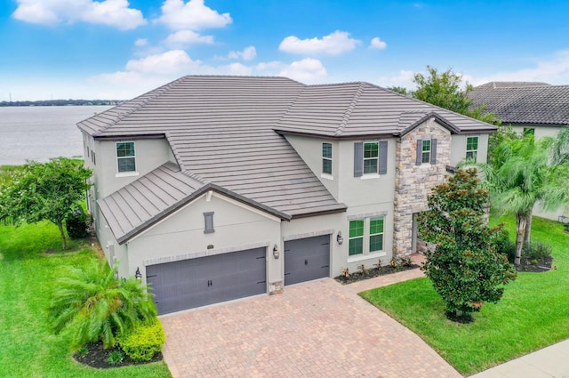 16689 Broadwater Ave, Winter Garden, FL 34787 - traditional-style home featuring stucco siding, stone siding, decorative driveway, and a front lawn
