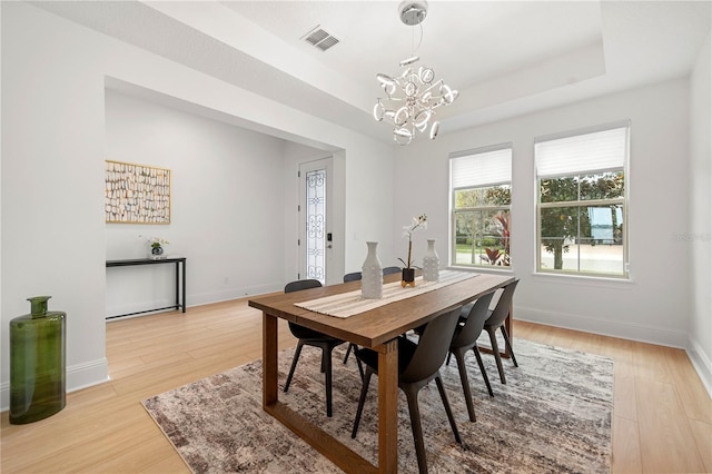 16689 Broadwater Ave, Winter Garden, FL 34787 - dining area with a tray ceiling, a chandelier, and light wood-style flooring
