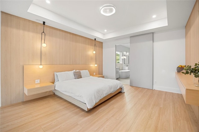 16689 Broadwater Ave, Winter Garden, FL 34787 - bedroom featuring a tray ceiling, light wood-style floors, recessed lighting, and ensuite bathroom