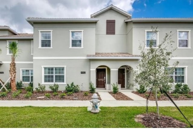 view of front of property featuring stucco siding and a front lawn