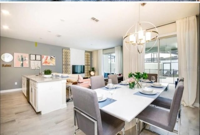 dining room with an inviting chandelier, baseboards, light wood-type flooring, and visible vents