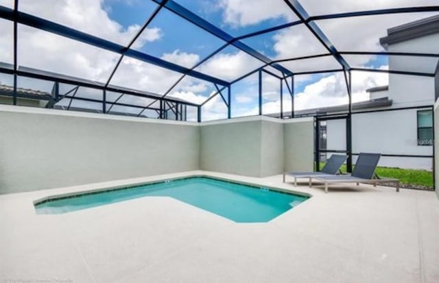 pool featuring glass enclosure and a patio