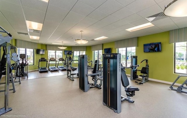 workout area with plenty of natural light, a paneled ceiling, and visible vents