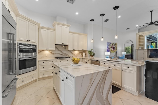 kitchen with a peninsula, light tile patterned floors, a sink, visible vents, and appliances with stainless steel finishes