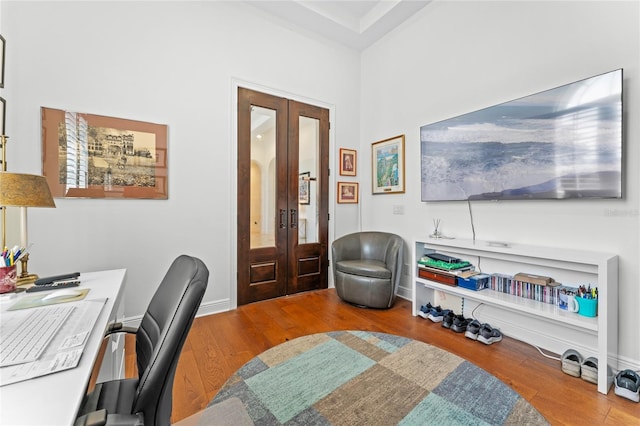 office space featuring baseboards, french doors, and wood finished floors
