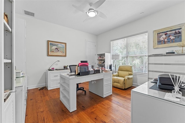 home office with ceiling fan, baseboards, light wood-type flooring, and visible vents