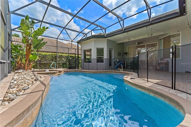 outdoor pool with a ceiling fan, a patio area, glass enclosure, and an in ground hot tub