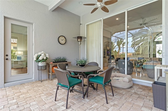 sunroom / solarium with a ceiling fan and outdoor dining space