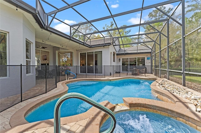 view of pool featuring glass enclosure, a patio, ceiling fan, and a pool with connected hot tub