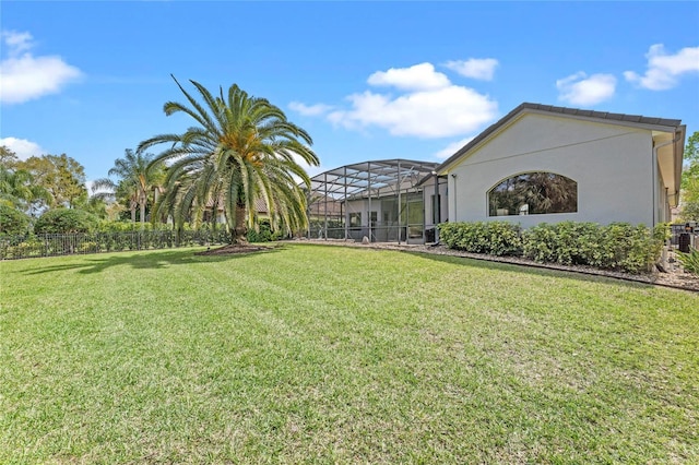 view of yard featuring fence and glass enclosure