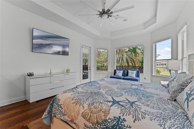 bedroom featuring baseboards, ceiling fan, access to outside, wood finished floors, and a raised ceiling