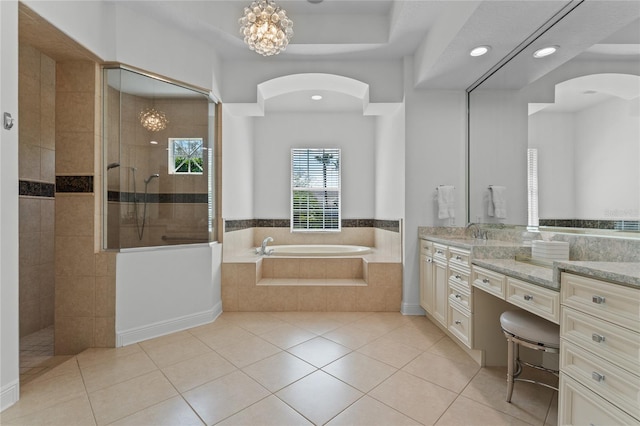 bathroom with vanity, tile patterned flooring, a walk in shower, a chandelier, and a garden tub