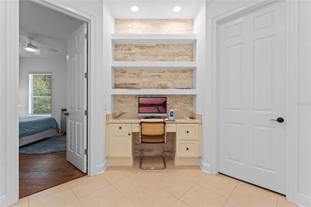 office area featuring built in desk, light tile patterned floors, baseboards, and ceiling fan