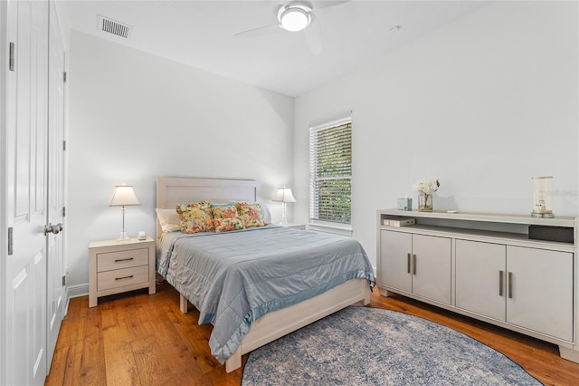 bedroom with a ceiling fan, light wood finished floors, and visible vents