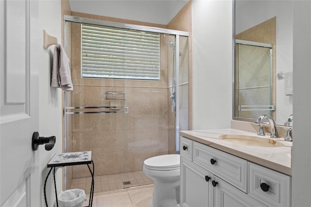 bathroom featuring vanity, toilet, a shower stall, and tile patterned floors