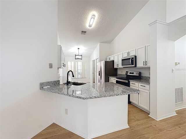 6921 Blair Dr, Orlando, FL 32818 - kitchen featuring visible vents, appliances with stainless steel finishes, a peninsula, light wood-style floors, and a sink
