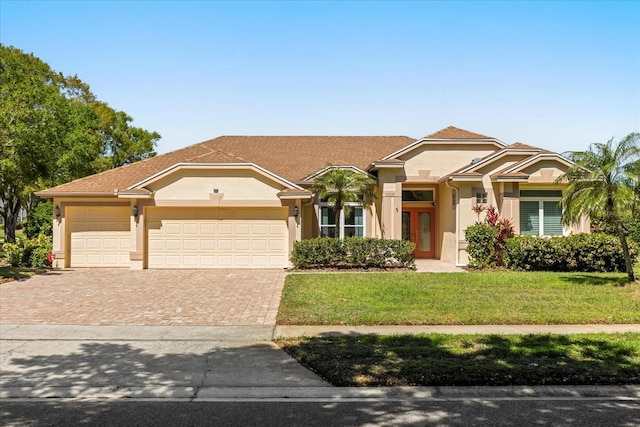 10337 Pointview Ct, Orlando, FL 32836 - view of front of home with stucco siding, an attached garage, a front lawn, and decorative driveway