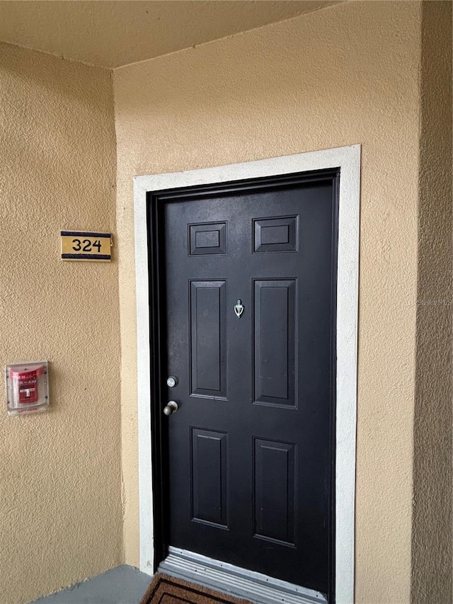 entrance to property featuring stucco siding