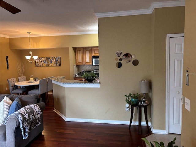 kitchen featuring dark wood-type flooring, stainless steel microwave, crown molding, decorative backsplash, and baseboards