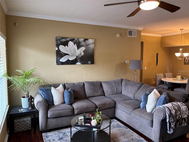 living room with wood finished floors, ceiling fan with notable chandelier, visible vents, and ornamental molding