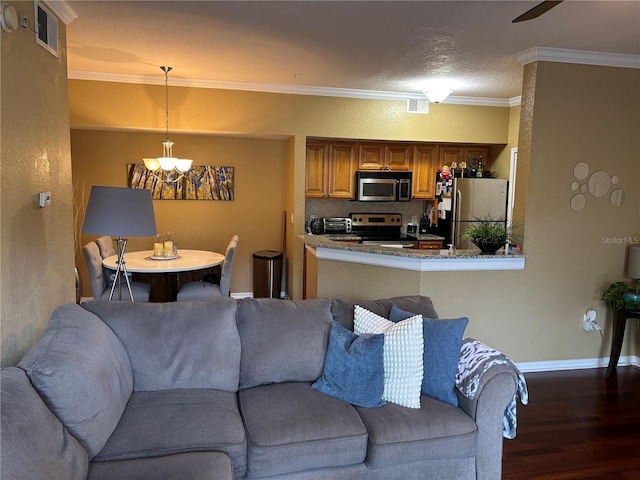 living area featuring visible vents, crown molding, baseboards, a chandelier, and wood finished floors