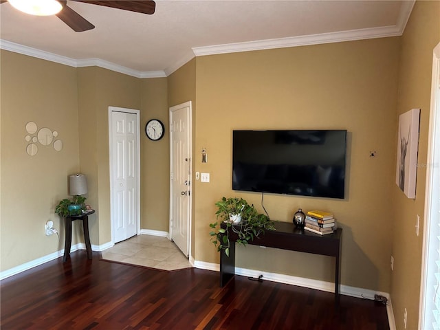 entrance foyer with baseboards, wood finished floors, ceiling fan, and ornamental molding