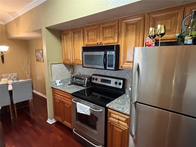 kitchen featuring backsplash, stainless steel appliances, crown molding, and brown cabinets