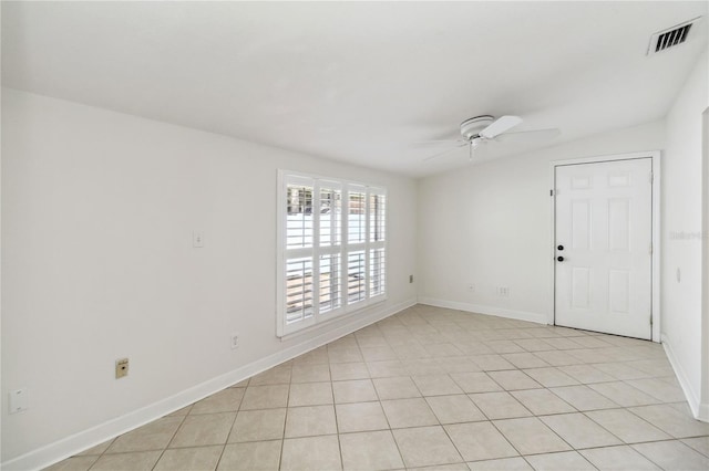 unfurnished room with light tile patterned floors, baseboards, a ceiling fan, and visible vents