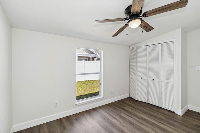 unfurnished bedroom featuring baseboards, a closet, dark wood-style flooring, and lofted ceiling