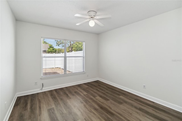 empty room featuring baseboards, ceiling fan, and dark wood-style flooring