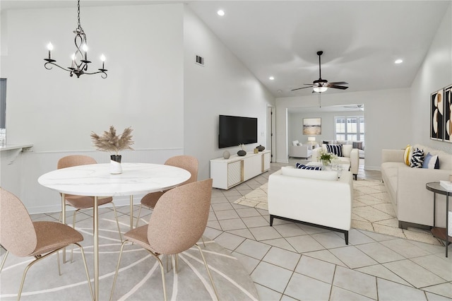 living room with light tile patterned flooring, high vaulted ceiling, ceiling fan with notable chandelier, recessed lighting, and visible vents