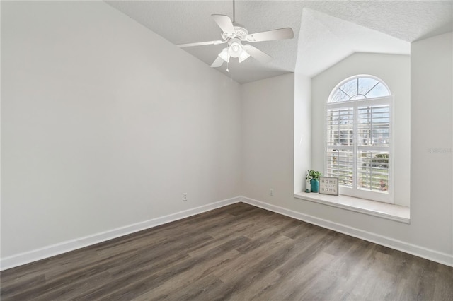 spare room featuring a textured ceiling, vaulted ceiling, and dark wood-style floors