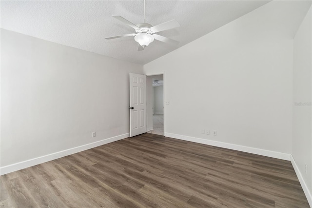unfurnished room featuring ceiling fan, vaulted ceiling, dark wood-style floors, and baseboards