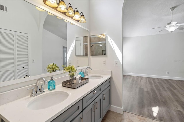 full bathroom featuring a sink, a ceiling fan, double vanity, and lofted ceiling