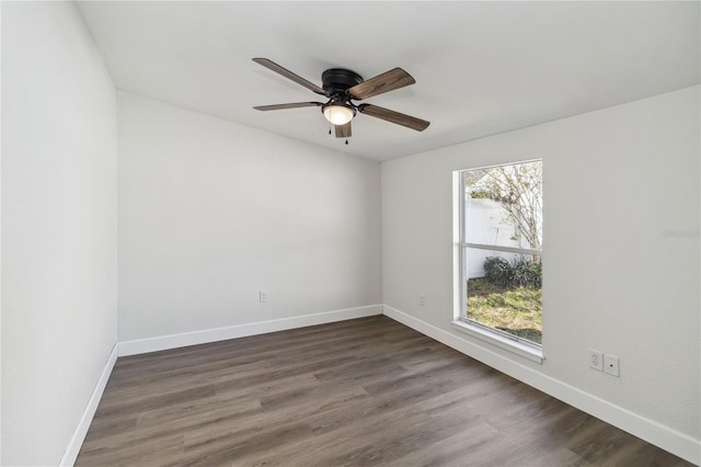 unfurnished room featuring baseboards, ceiling fan, dark wood-style floors, and a wealth of natural light