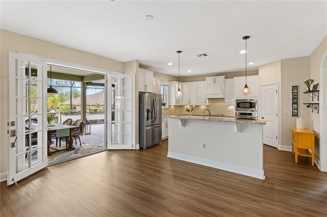 kitchen with white cabinets, visible vents, a wealth of natural light, and stainless steel appliances