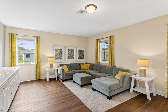 living area featuring dark wood finished floors, baseboards, and visible vents