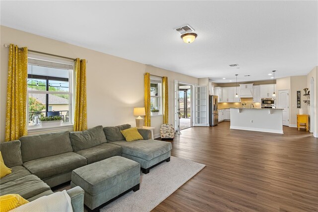 living area featuring dark wood finished floors, recessed lighting, visible vents, and baseboards