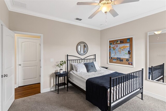 bedroom featuring carpet flooring, visible vents, crown molding, and baseboards