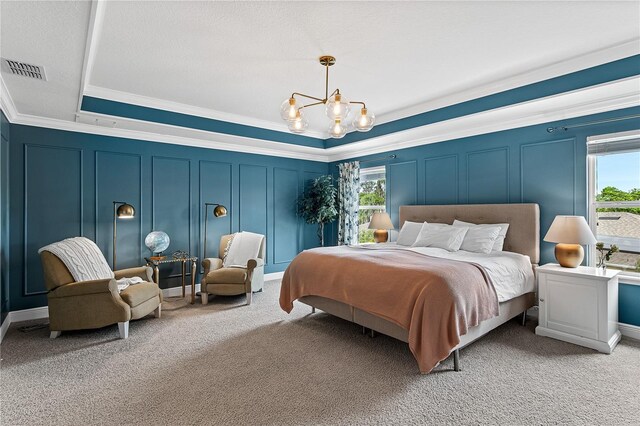 carpeted bedroom featuring visible vents, ornamental molding, a raised ceiling, a decorative wall, and a notable chandelier