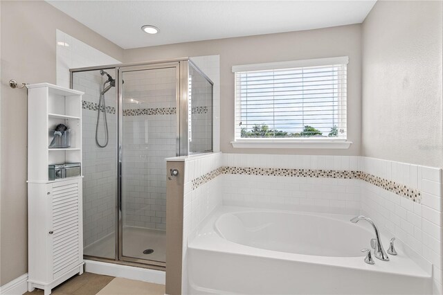 bathroom featuring a stall shower and a garden tub