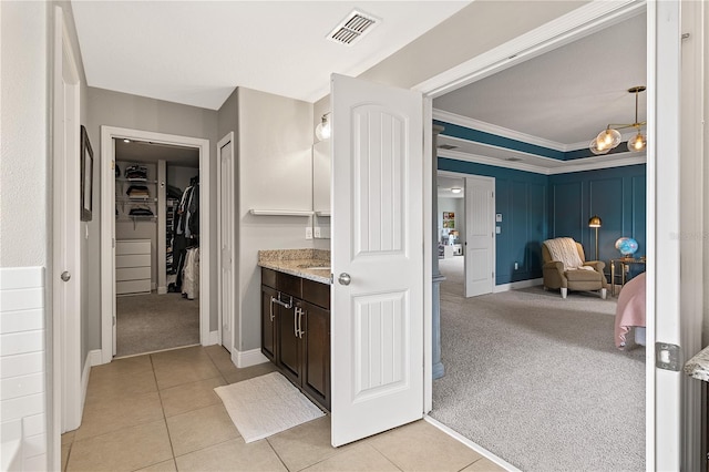 ensuite bathroom featuring vanity, visible vents, ensuite bath, ornamental molding, and tile patterned floors